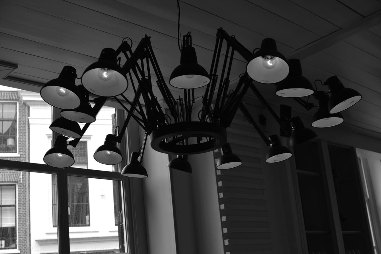 Sfeervol samenstel van hangende lampen bij het erkerraam van Brasserie Stadhuis.